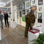 Gallery 2 - Patron looking closely at a piece of artwork.
