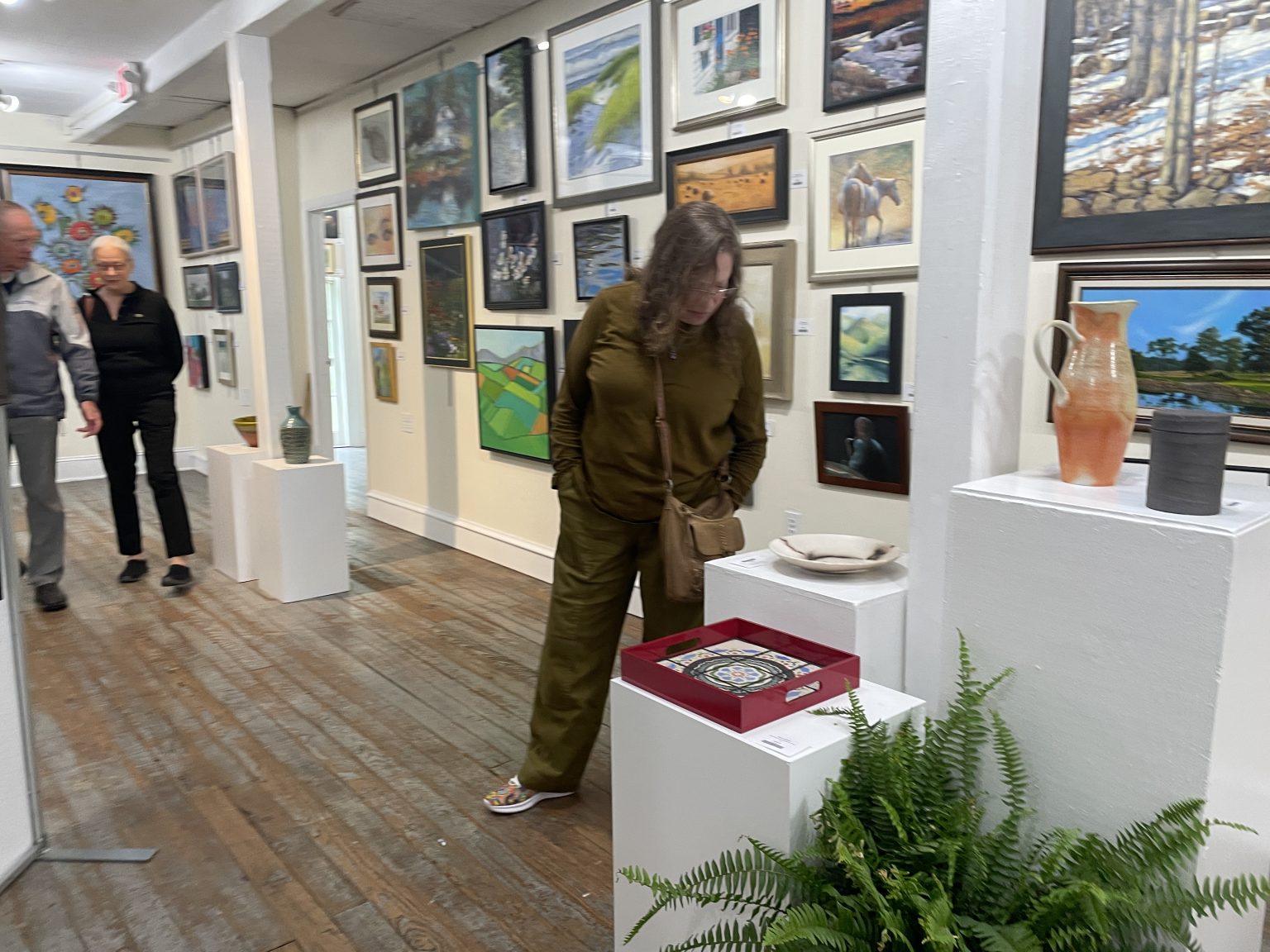 Gallery 2 - Patron looking closely at a piece of artwork.